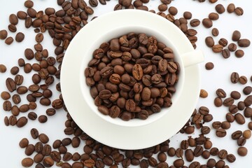 Aromatic coffee beans and cup on white background, flat lay