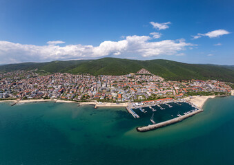 Panoramic aerial view of Sveti Vlas, Bulgaria, showing the marina, beaches, red-roofed buildings, and lush green hills along the Black Sea coast. Popular summer resort town