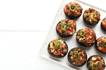 Delicious stuffed mushrooms on white wooden table, top view. Space for text