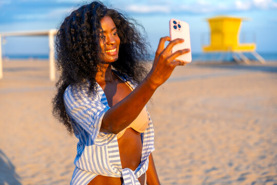 Tourist taking selfie on beach with smartphone