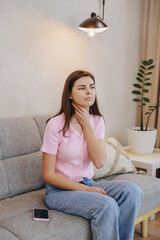 Young Woman Suffering from Sore Throat at Home