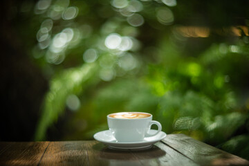 Background Coffee cup and beans on old kitchen table. Hot art Latte Coffee.
