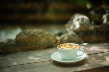 Background Coffee cup and beans on old kitchen table. Hot art Latte Coffee.
