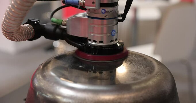 4k slow motion video with a robot equipped with a sanding brush polishes a piece of metal.