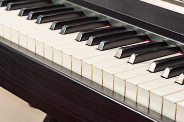A close-up, high-angle shot of the black and white keys of a digital piano or keyboard instrument.
