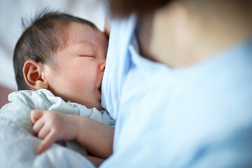 Mother nursing her newborn baby in a cozy setting during daylight hours