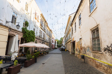 harming Historic Timisoara Romania Old Town Street With Traditional European Architecture Outdoor Cafe Terraces And Decorative String Lights Creating Romantic Atmosphere