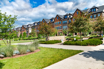 row of Modern multi-family townhouses with landscaping.