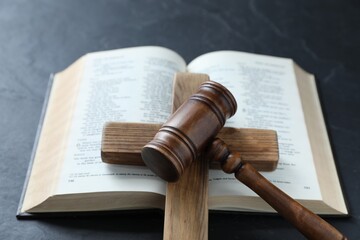Fototapeta premium Judge's gavel, Bible and wooden cross on black table, above view