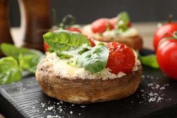 Tasty stuffed mushrooms served on wooden table, closeup