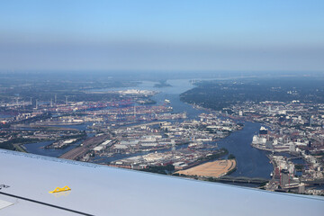 Fototapeta premium The industrial area of ​​the port of Hamburg photographed from a passenger plane landing at Hamburg International Airport. Selective focus.