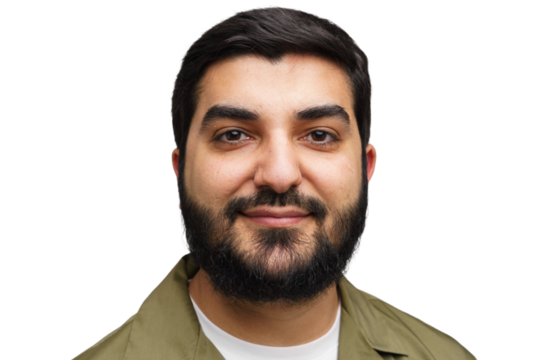 Smiling man with a beard wearing a green jacket poses for a friendly portrait in a bright setting