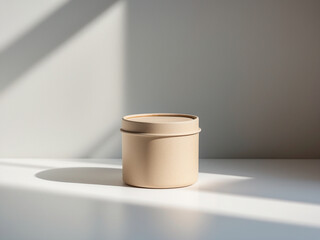 Minimalist white cylindrical candle in a metal tin, resting on a soft, textured grey blanket. Evokes comfort, warmth, and home decor themes.