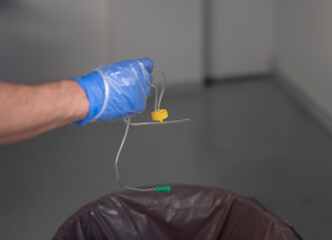 Doctor disposing of used iv catheter in hospital setting