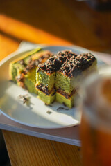 Matcha chocolate roll cake, Dessert made from green tea and chocolate blend with grated chocolate topping. Sliced ​​into squares on a plate