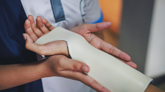 Therapist making asissistive device for immobilize patient hand and wrist. Splint service for hand injury rehabilitation of occupational therapy clinic.