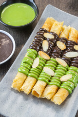 Cheese Roll Stick with chocolate topping and almond slices. crunchy snack made by wrapping cheese in a thin pastry or spring roll wrapper, then deep frying it until golden and crispy