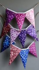 Colorful polka dot bunting flags hanging on gray wall