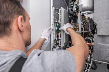 Technician Performs Maintenance on a Residential Heating System in a Modern Home Setting