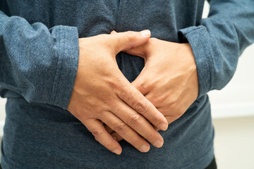 Hernia, Asian man stomach ache, abdominal pain and urology problem health.
