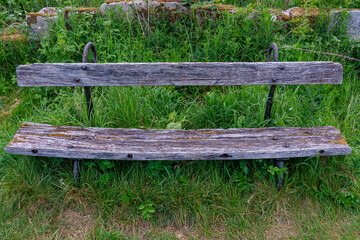 Naklejka premium Old wooden bench in the grass