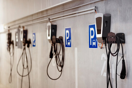EV Charging Station at Parking Lot. Private ev Charger on the Wall in Urban Garage Parking of Apartment Building. Wall Home Charger with Meter Inside for Electric Car.