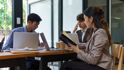 Business team discussing strategy and reviewing documents together at a shared desk.