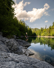 Bergsee mit einem Mann der am Ufer steht - am Almsee in Österreich im Sommer