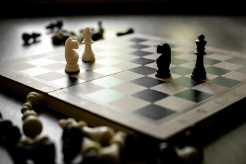 White chess knight piece and other pieces on chessboard during the game