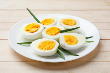 Boiled eggs and green onions on wooden table, closeup