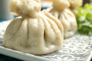Delicious cooked khinkali served on table, closeup