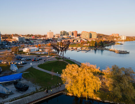 City of Barrie downtown waterfront aerial panorama drone shot. Lake Simcoe marina, condo buildings, banks, parks and infrastructure. Sunny day, blue sky.