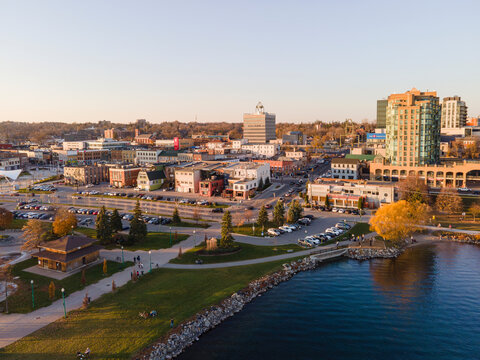 City of Barrie downtown waterfront aerial panorama drone shot. Lake Simcoe marina, condo buildings, banks, parks and infrastructure. Sunny day, blue sky.