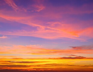 Obraz premium A breathtaking sunset casts vibrant hues of orange and pink across the ocean, with silhouetted mountains framing the serene landscape.
