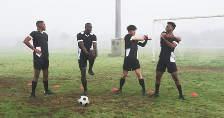 Soccer players warming up on foggy field, preparing for practice session - Powered by Adobe