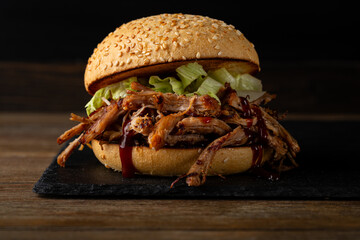 Close up of beef  burger on dark surface hero view