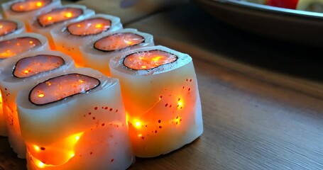 Glowing sushi rolls are beautifully arranged on a wooden board, creating a magical culinary experience.