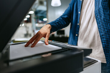 Obraz premium Person operating a printer to copy documents in a modern office environment