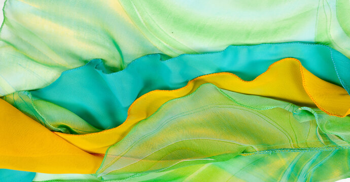 Seamless kaleidoscope. Fabric silk green-blue shades. Vibrant colors and scalloped shapes create a truly unique crepe de chine in yellow, blue and green geometric silk crepe de chine.