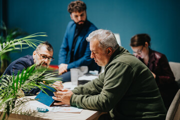 A group of business professionals works together on a project in a modern workspace. Focused...