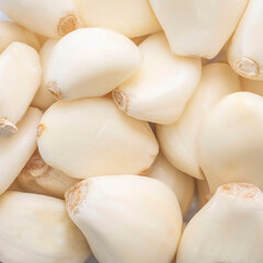 Close-up of stacked peeled garlic cloves. Square format. Background