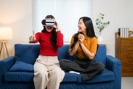 Two friends are playing with a vr headset in their living room