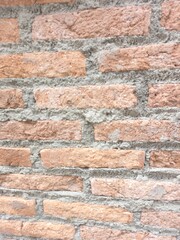 Classic red brick wall with rough cement joints. Natural construction photography for background, texture or wallpaper.