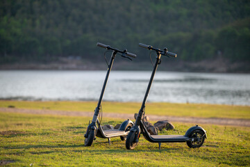 Two scooters are parked on a grassy field