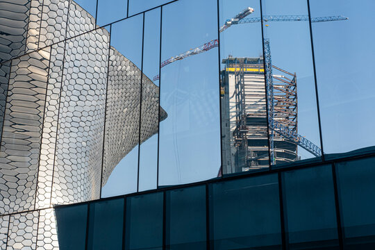 Architectural reflections on glass skyscrapers, blending light, shapes, and urban textures, ideal for design, office environments, and background stock photography.