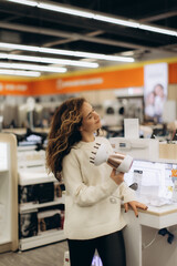 Young Woman Shopping for Electronics in a Modern Retail Store Environment