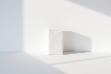 A white bag stands on a white surface against a white background with light and shadow adding dimension