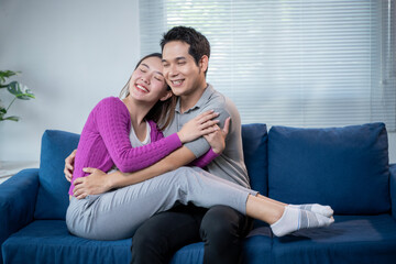 Obraz premium A man and a woman are sitting on a blue couch