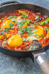 Shakshuka with mushrooms and yellow peppers topped with eggs and cilantro