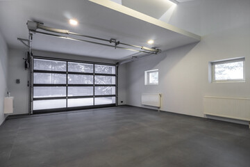 A bright and spacious garage features large glass doors letting in natural light. The clean floor...